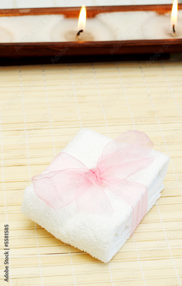 Relaxing spa scene with small white towel with pink organza Relaxing spa scene with small white towel with pink organza