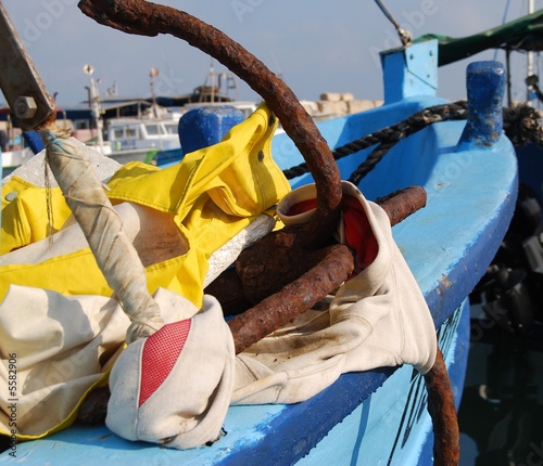 Old rusty anchor on blue boat
