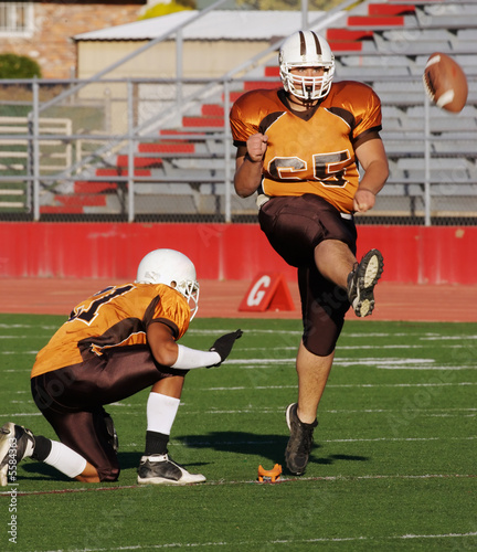 Kicking a football field goal during a high school game