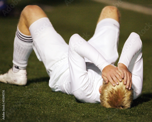 Soccer player saddened after game loss photo