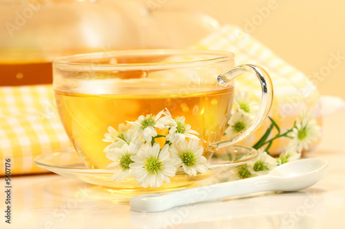 Glass tea cup with herbal tea and flowers