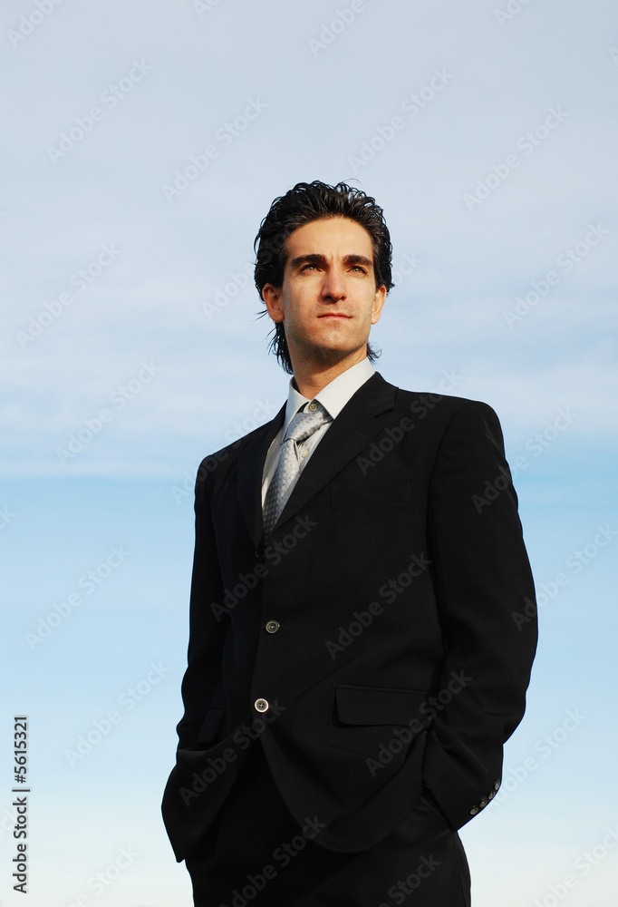 confident and successful businessman is posing against the sky confident and successful businessman is posing against the sky