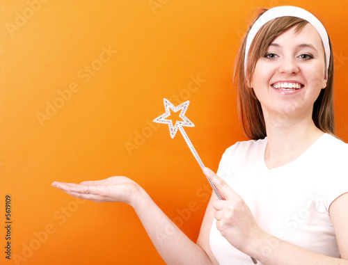 Beutiful and happy fairy with wand in the hand.