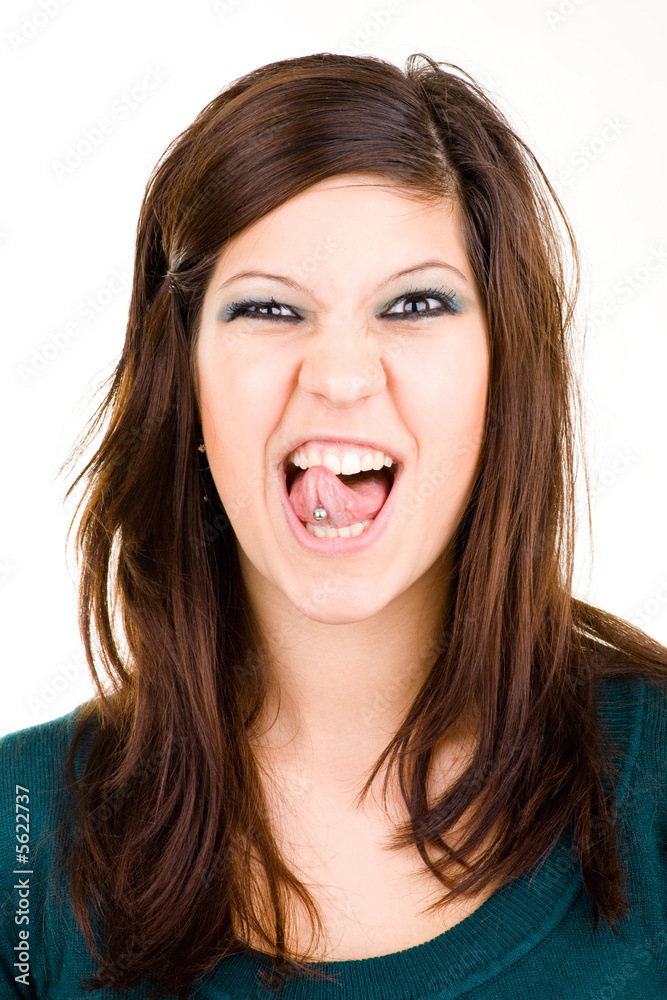 Freches Mädchen streckt Zunge mit Piercing heraus und zwinkert Freches Mädchen streckt Zunge mit Piercing heraus und zwinkert