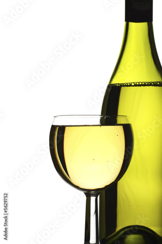 wine bottle and glass of freshly poured white wine.