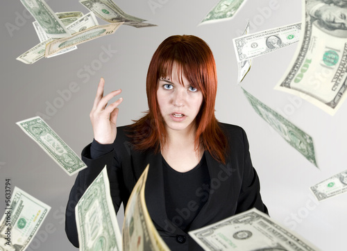 Angry and pretty redhead girl throwing Dollar banknote money
