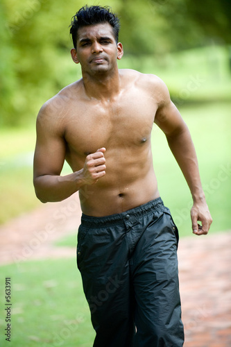 A young man with no top on running outside © EastWest Imaging