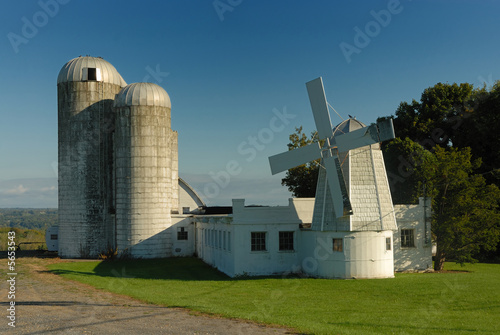Obraz w ramie silos under a cloudy sky with foreground greenery