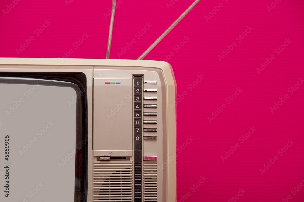 Obraz premium Detail of an old vintage tv set against pink wall