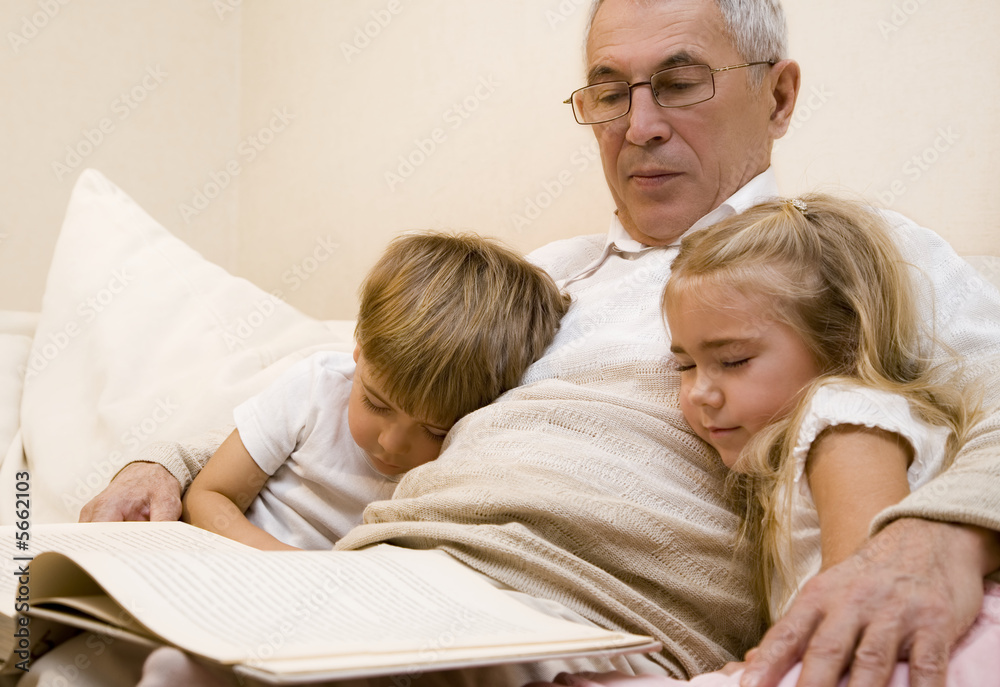 Grandpa is reading book to his grandchild  