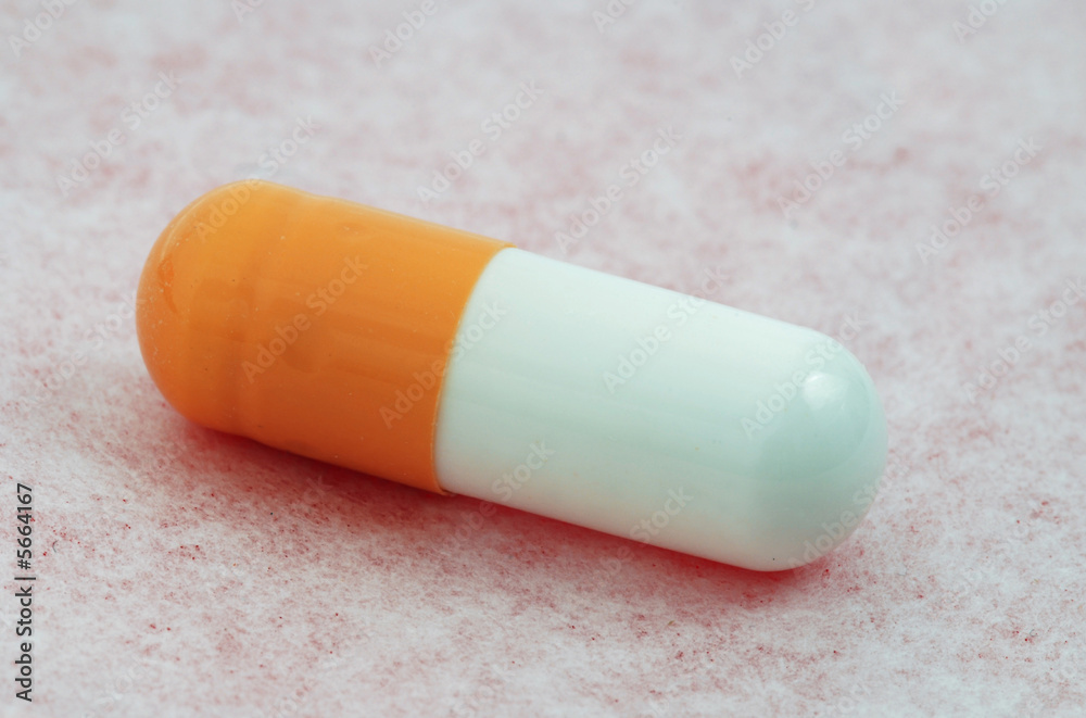 Single medical capsule macro isolated on the pink surface Single medical capsule macro isolated on the pink surface