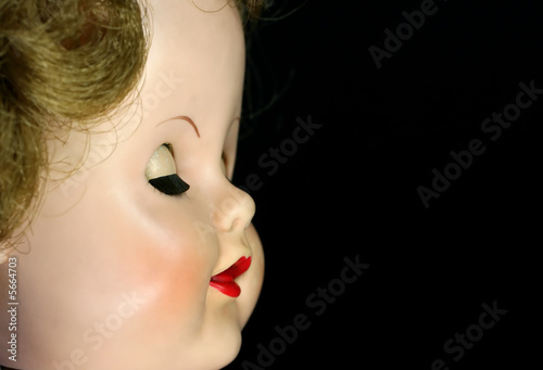 A close up of an antique doll with her eyes closed photo