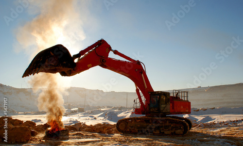 Ladle of a loader heat above a burning tire cover