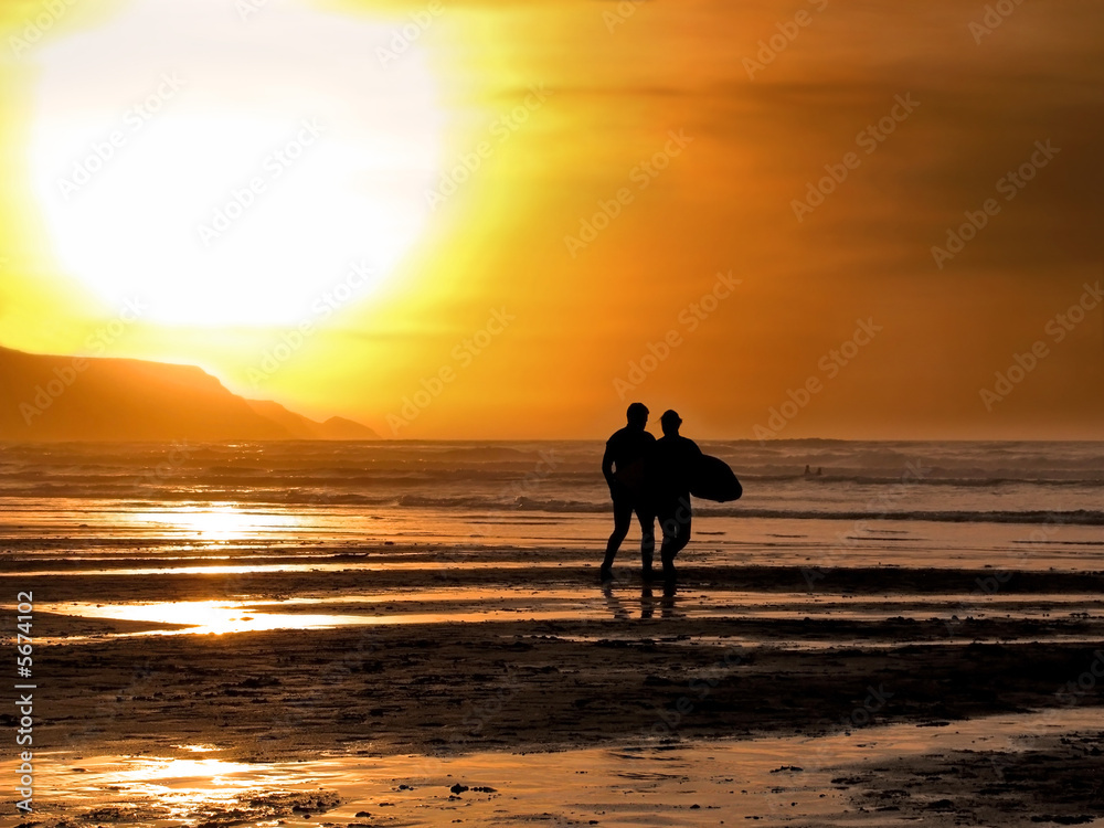 Silhouette of a male and female surfer