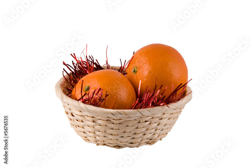 Two ripe oranges lay in a wum basket on a white background photo