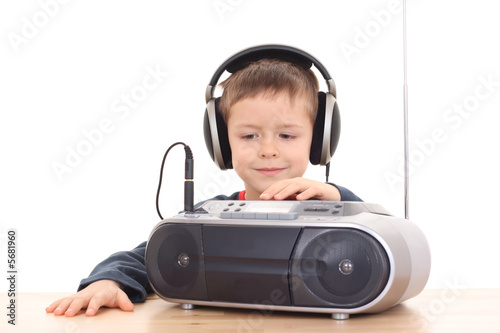 cute 6 years old boy listening to music isolated on white