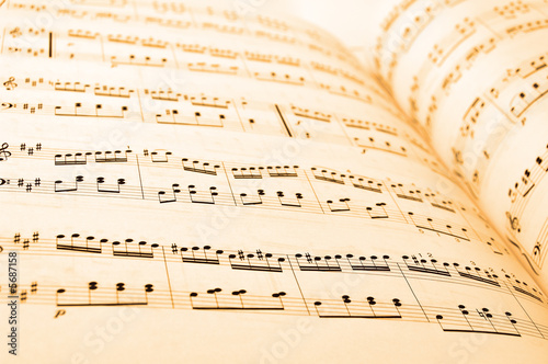 Close-up of sheet music in yellow lighting