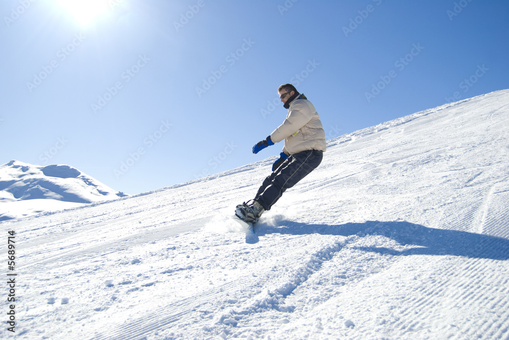 Snowboarder having fun in a bright sunny day stock photo