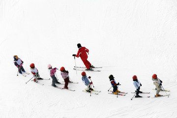 Fotobehang Wintersport Kinderen leren skiën met instructeur  © Diego Cervo