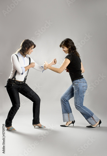 Two young beautiful sisters having fun simulating a fight 