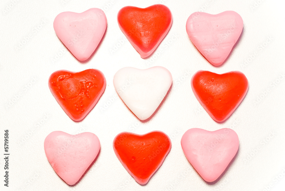 Close up red and pink candy hearts in square isolated on white