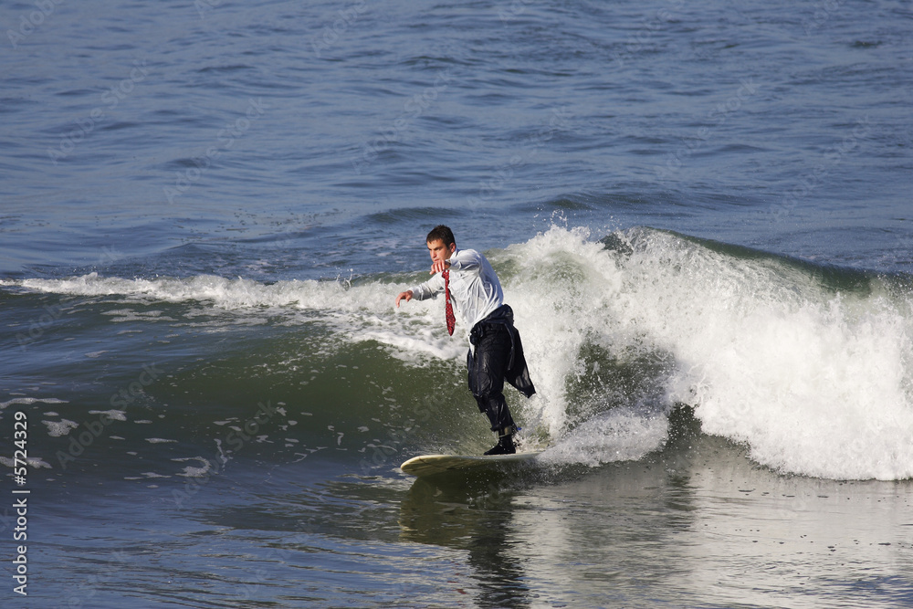 homme en smoking entrain de surfer une vague