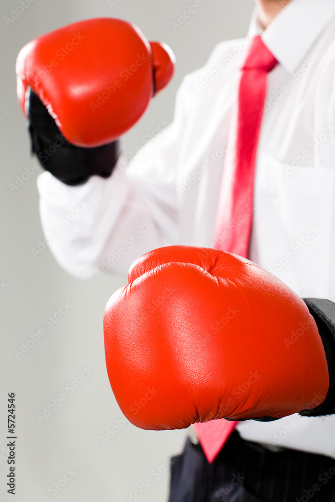 Vertical photo of a business man in red boxing gloves