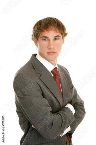 Serious young businessman with arms crossed 