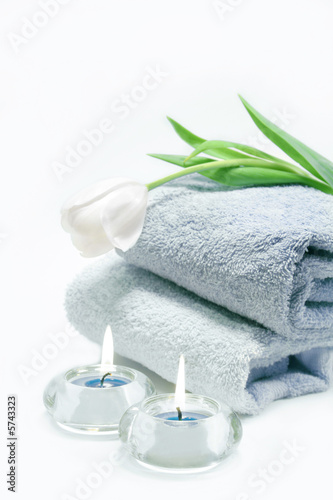 Blue towels, lit candles with white tulip