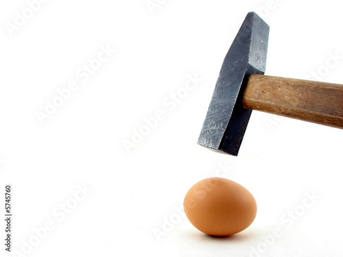 Hammer and egg isolated concept of power photo