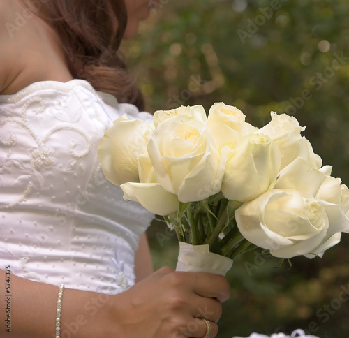  bride in white holding bouquet of roses