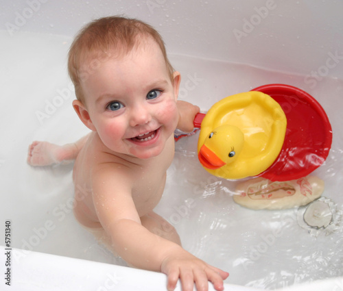 The child bathing in a bath and playing toys