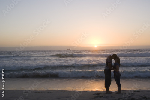 silhouetted couple kissing at sunset on a cape town beach