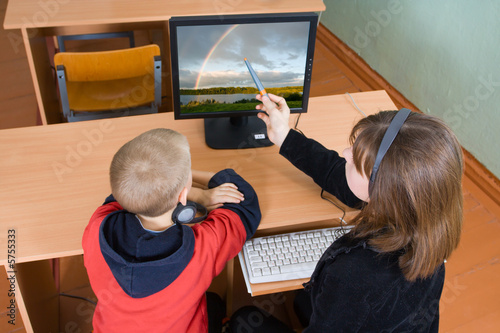 Schoolboys in a computer class work behind computers