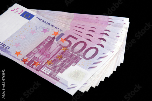 500 Euro bills currency on a black background