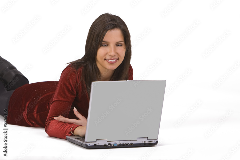 Beautiful young woman lying down and working on a laptop. Beautiful young woman lying down and working on a laptop.