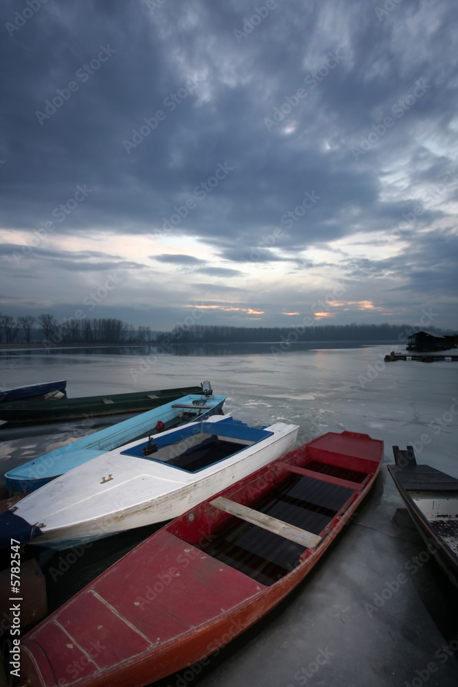 Fototapeta premium old boat on frozen river Danube in january