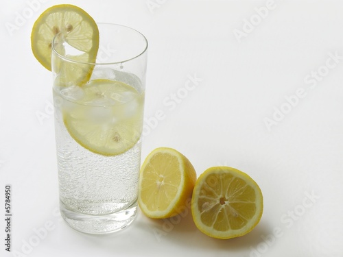 minerale water with lemon slices,lemons and pipe for drinking
