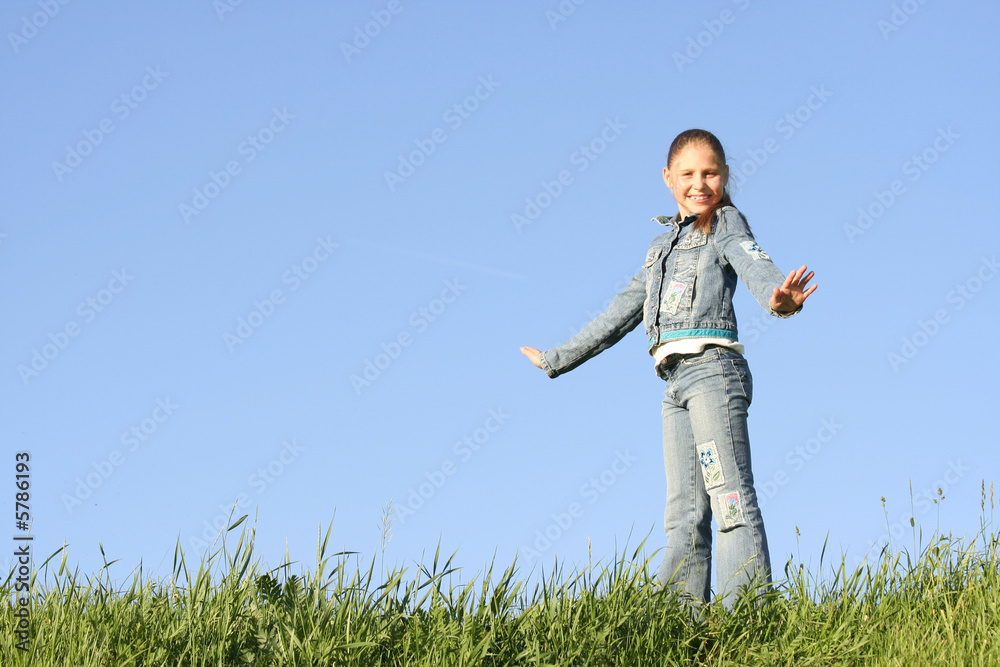 Girl costs on a grass on a background of the blue sky Girl costs on a grass on a background of the blue sky