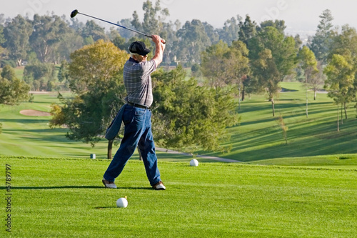 A golfer plays a round of golf at the country club resort