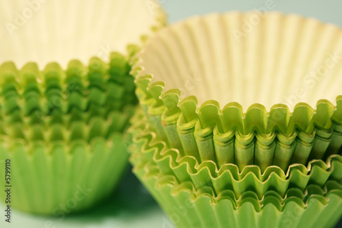 Close-up of green paper baking cups on a soft blue background