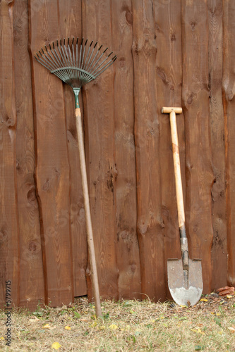 Two usual tools for gardening - a rake and a spade