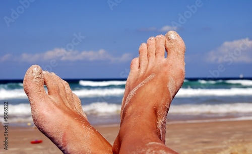 female feet on back-ground sea in sand.
