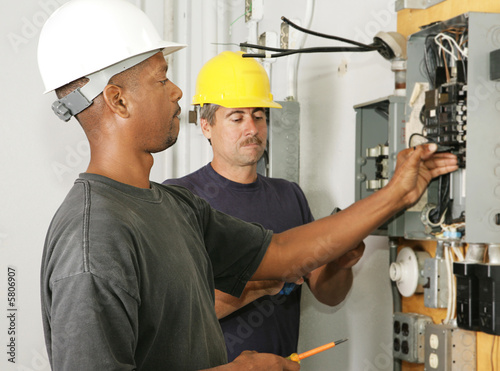 An african american and a caucasian electrician working 
