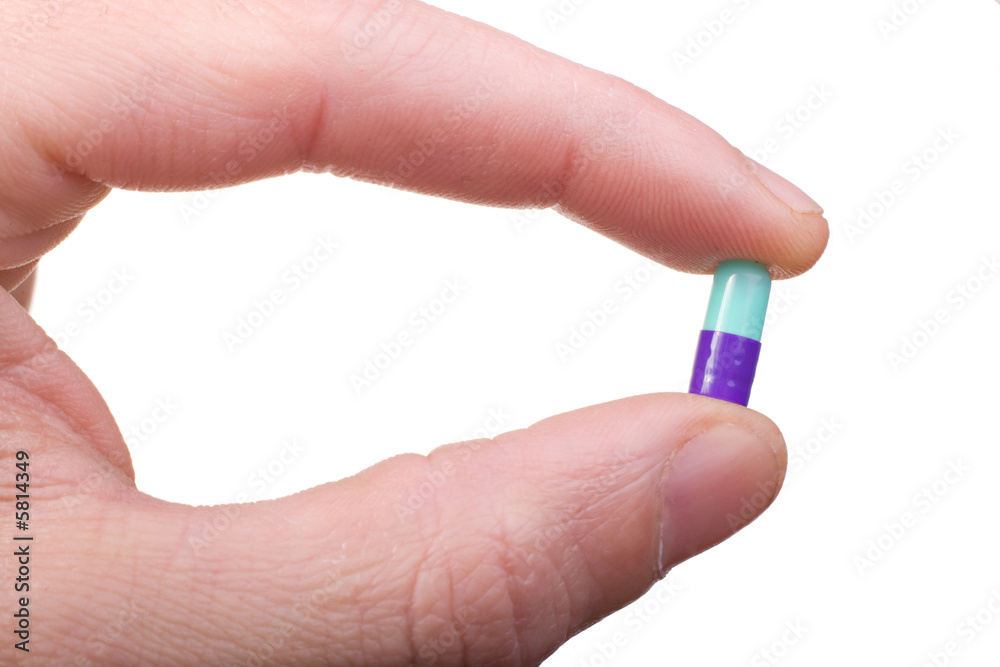 hand closeup showing a medical pill isolated on white hand closeup showing a medical pill isolated on white