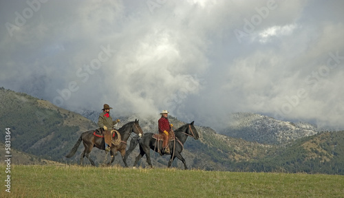 Fotografija Cowboys riding the range. Front lit with storm clouds