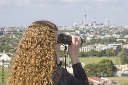 Lady looking at the view of Auckland NZ with binoculars