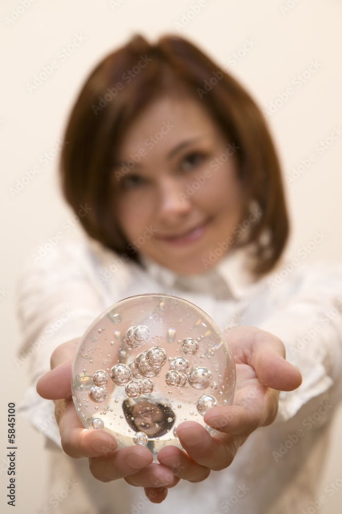Young woman holds a glasses ball in her hands Young woman holds a glasses ball in her hands