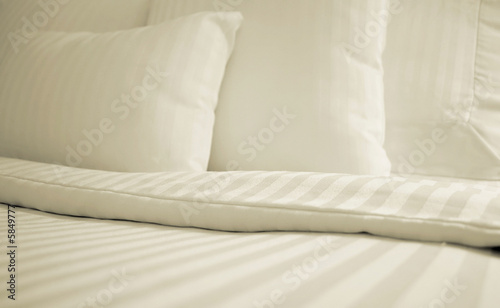 Bed with set of crisp striped sheets and pillows