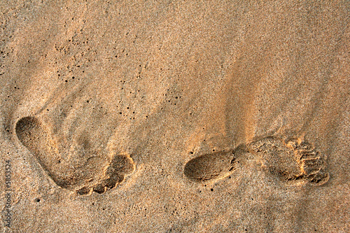 foot prints on the beach sand on sunrise photo